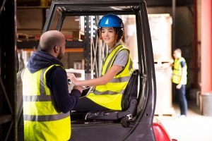 female forklift driver chatting to training supervisor