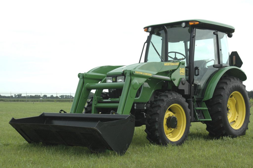 Farm tractor with a loader extension